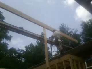 Carpenter setting a ridge beam over a new addition frame in North Salt Lake